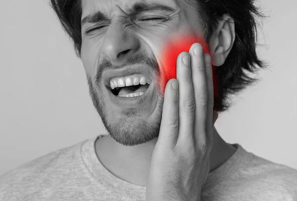 man experiencing pain on his jaw, gums, or teeth