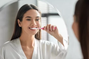 brunette woman brushing her teeth