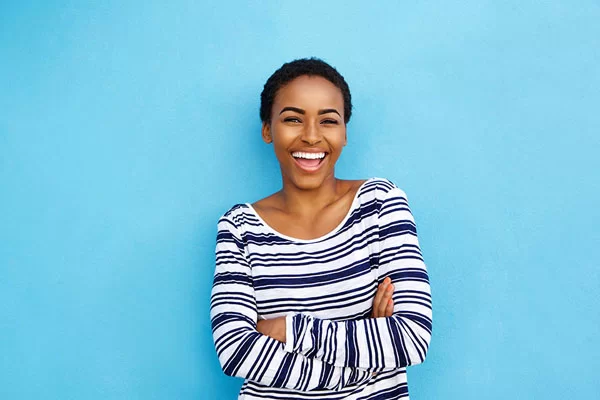 young black lady smiling with a light blue background behind her