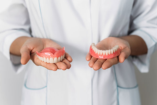 dentist holding dentures