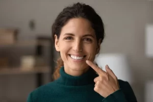 woman pointing at her smile